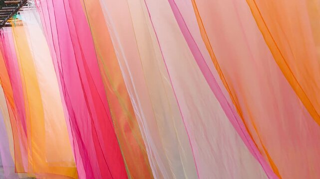 Exploring colorful textile textures through dynamic close-up of transparent fabric, with flowing folds and layered shades creating artistic abstract background, shot handheld. High quality 4k footage