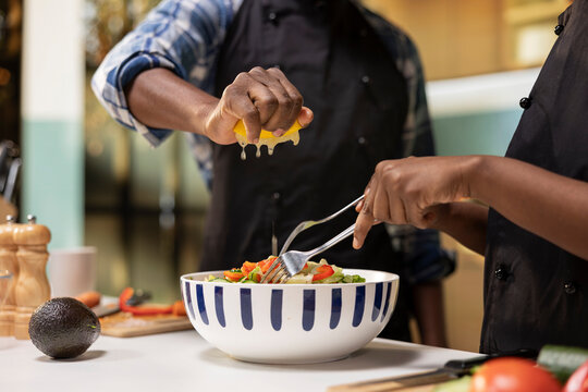 Close-up of man squeezing lemon juice over produce
