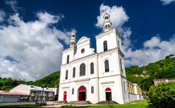 The white facade of Our Lady of the Assumption Cathedral against a blue sky with clouds in Saint-Pierre, Martinique, Caribbean France