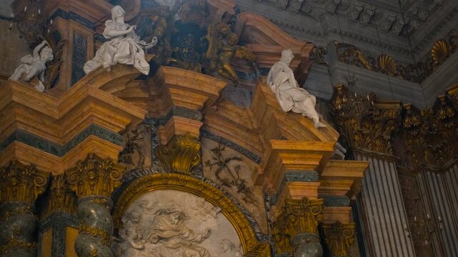 Baroque cathedral interior revealing ornate altar. Ornate altar in a historic baroque cathedral revealing incredible details, marble statues, and golden decorations. European religious architecture