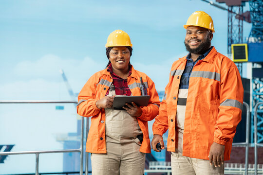 Happy engineers inspect offshore platform components to avoid downtime, while cheerful drilling rig coworkers use diagnostic tools to detect malfunctions in subsea pipelines during inspection.