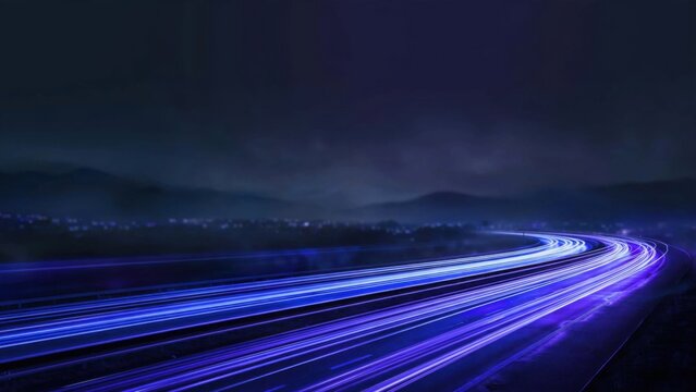Streaks of vibrant blue and purple light blur across a dark highway curving through misty mountains