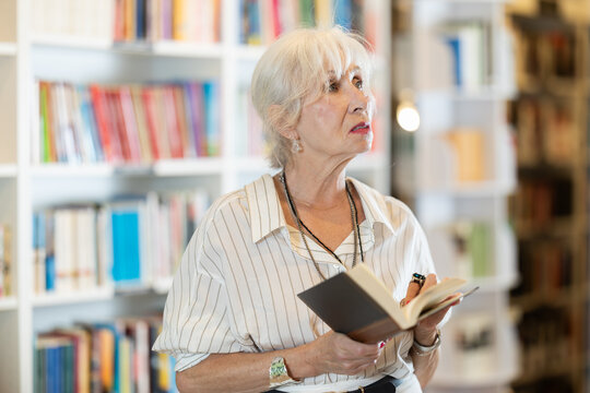 Senior female reader explores aisles of bookstore, looking for new title to enjoy
