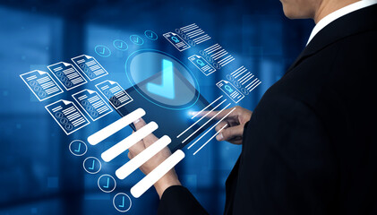 A businessman interacts with a digital tablet featuring a holographic interface that displays...