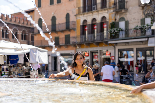 Woman cooling off at a public fountain in Verona, Italy