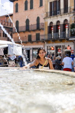 Smiling woman beside a fountain in Verona, Italy