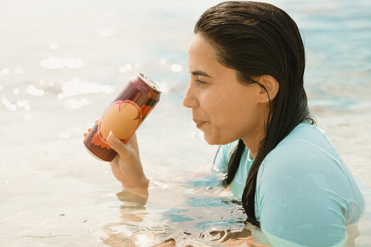 Woman holding a drink while relaxing in tropical water in the Philippines