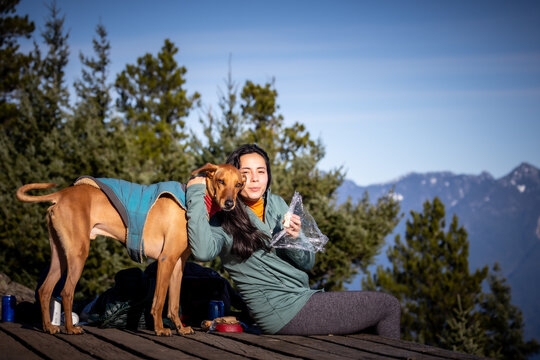 Woman resting with her dog at a scenic viewpoint on Bowen Island