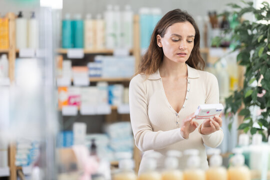 Girl in summer clothes buys paracetamol medicine at a pharmacy