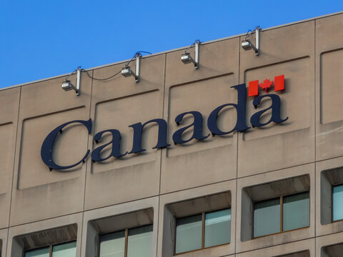 Ottawa, Ontario, Canada. Sep 9, 2026. Low angle view of official Canada wordmark logo with maple leaf on concrete federal building facade.