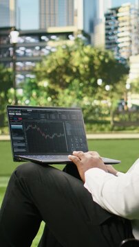 Vertical aspect: Businessman studying financial trading charts on forex platform