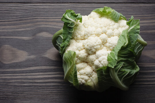 Raw head of cauliflower on wooden table