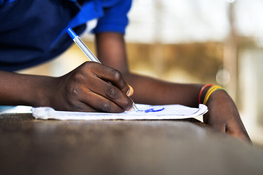 A young African boy sketching on a paper