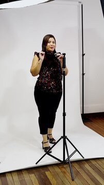 Plus-size woman vlogging with a camera on a tripod