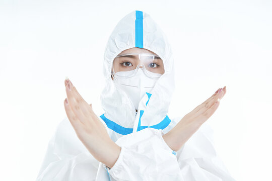Female medical staff wearing white protective suits, goggles, and masks