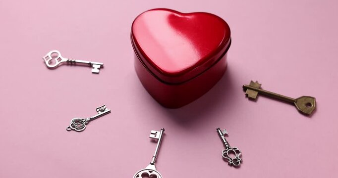 Choice concept. Heart shaped box and different keys on pink background, closeup