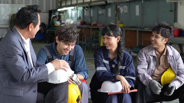 Asian worker industrial workplace group discussion with safety helmet, smiling employee teamwork, factory engineer and supervisor discussing equipment, diverse coworkers collaborative workshop