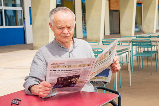 World news, an old man reading a newspaper.