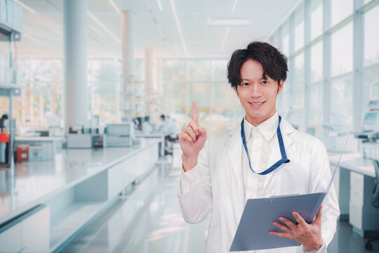 白衣を着て研究室で研究をする男性の研究員