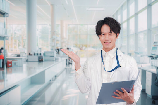 白衣を着て研究室で研究をする男性の研究員