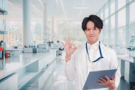 白衣を着て研究室で研究をする男性の研究員
