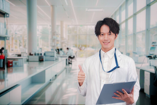 白衣を着て研究室で研究をする男性の研究員