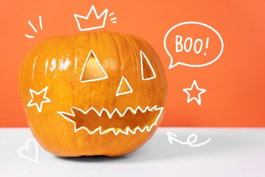 A carved jack o lantern pumpkin with a toothy grin sits on a white surface against an orange backdrop, surrounded by hand drawn doodles including a speech bubble reading boo, a crown, star and heart.