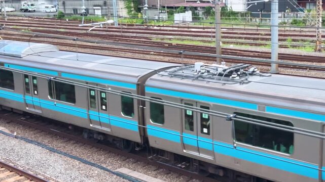Keihin-Tohoku Line commuter train cutting across a dense field of parallel tracks near Tsurumi, Yokohama