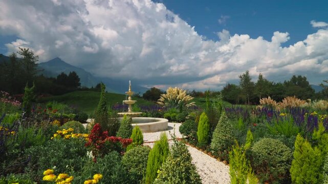 Colorful garden with fountain, flowers, and mountains