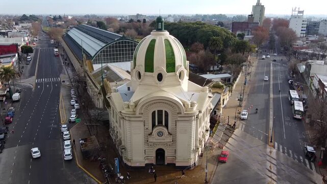 Drone moves vertically upward showing the dome shrinking as the platforms and tracks of La Plata Train Station are revealed in Argentina.