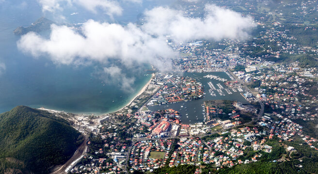 High altitude aerial view of Rodney Bay Marina, coastal beaches, and residential towns under scattered clouds in Saint Lucia.