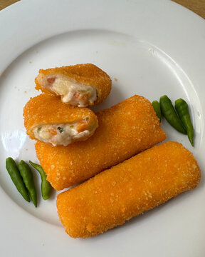 "Golden brown fried croquettes or risoles with creamy ragout filling served as a traditional savory snack."