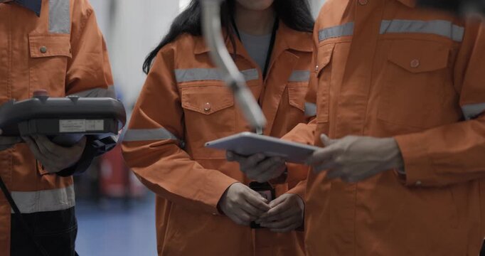 Female and Male engineers checking or maintenance electronic in AI or artificial intelligence robot arm in the manufacturing automation and robotics manufacture room. Service technical engineer.
