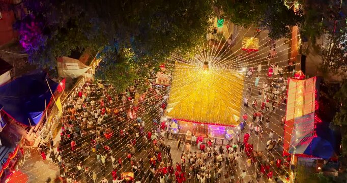 Kathmandu, Nepal, aerial view of the radiant golden-draped Maitidevi Temple, illuminated with festive light strings and filled with Hindu devotees celebrating Tihar night.