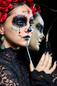 Halloween beauty portrait of woman with Santa Muerte makeup. Female with a shard of the mirror.