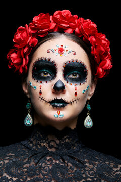 Halloween beauty close-up portrait of woman. Beautiful female face adorned with Santa Muerte makeup.