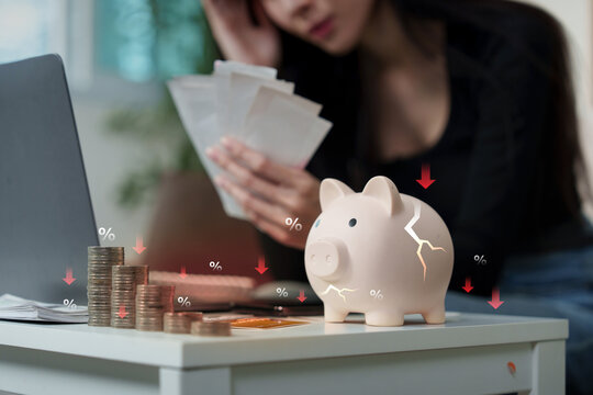 Financial crisis concept with cracked piggy bank coins and stressed woman for inflation loss