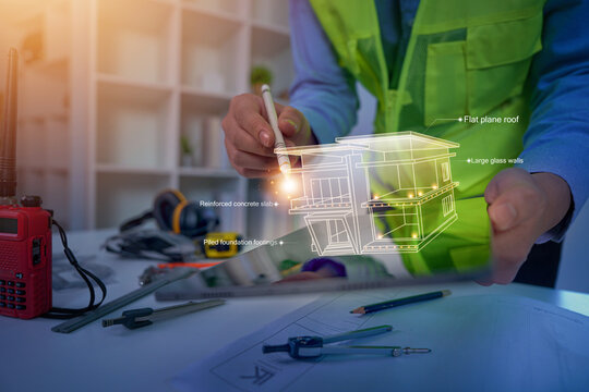 Architect holding stylus over tablet with digital house model blueprint for engineering design