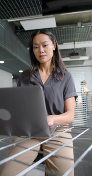 Woman Focusing on Laptop in Modern Open plan Workspace