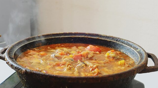 Vegetables with chicken and mushrooms are simmered in a deep cast iron skillet