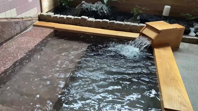 和の情緒あふれるヒノキの露天風呂と清らかな温泉の流れ