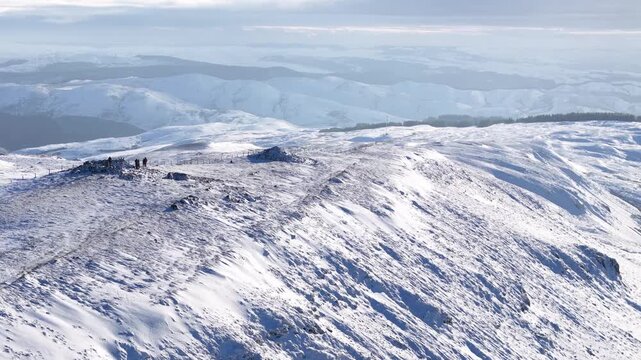 Aerial drone footage of Plynlimon summit covered in snow, revealing sweeping views across the surrounding rugged mountains and remote Welsh winter landscape.