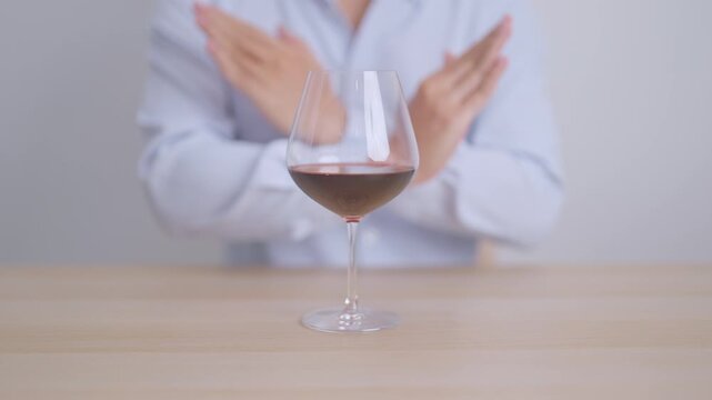 man making stop hand gesture to refuse a glass of Wine, Healthy man say no to alcohol drink, stop alcoholism and addiction concept. Responsible man reject a drink before driving and quit booze