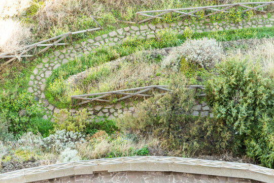 Italy, Sardinia, Castelsardo.  Overhead view of winding footpath below the castle walls.