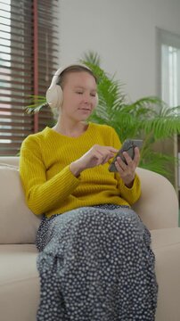 Happy woman listening to music on smartphone with headphones