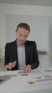 Businesswoman talking and analyzing charts during a video call