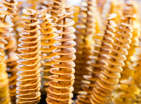 Spain, Barcelona, Boqueria Market.  Spiralized deep fried potatoes on skewers for sale at the market.