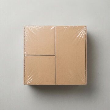 Three stacked brown cardboard boxes wrapped in clear plastic for shipment and storage with packaging