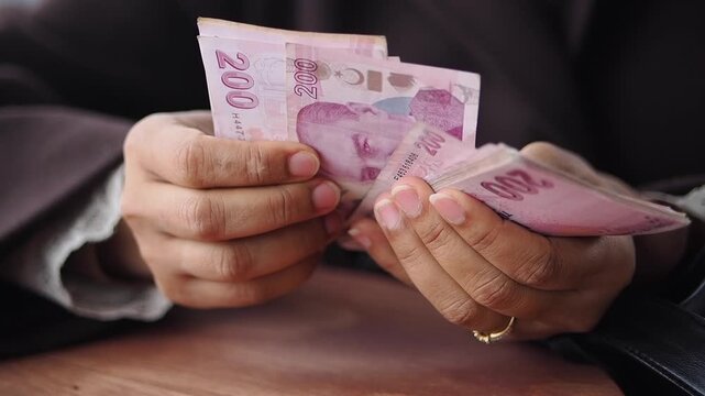 Counting Turkish Lira notes in a cafe