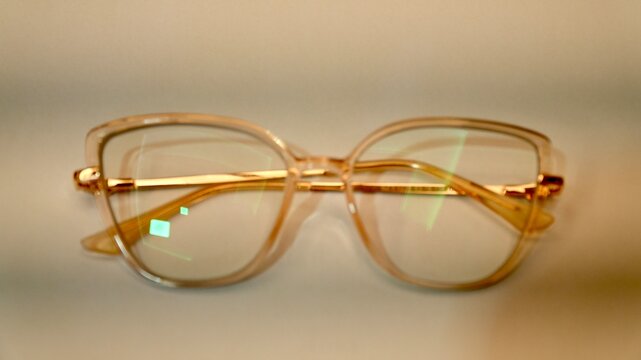 Elegant gold cat-eye eyeglasses resting on a modern minimalist surface.